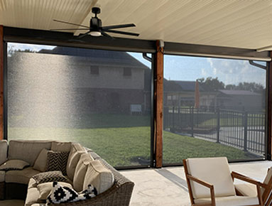 Covered patio motion screens providing shade and airflow with ceiling fan integration in Lafayette, Louisiana