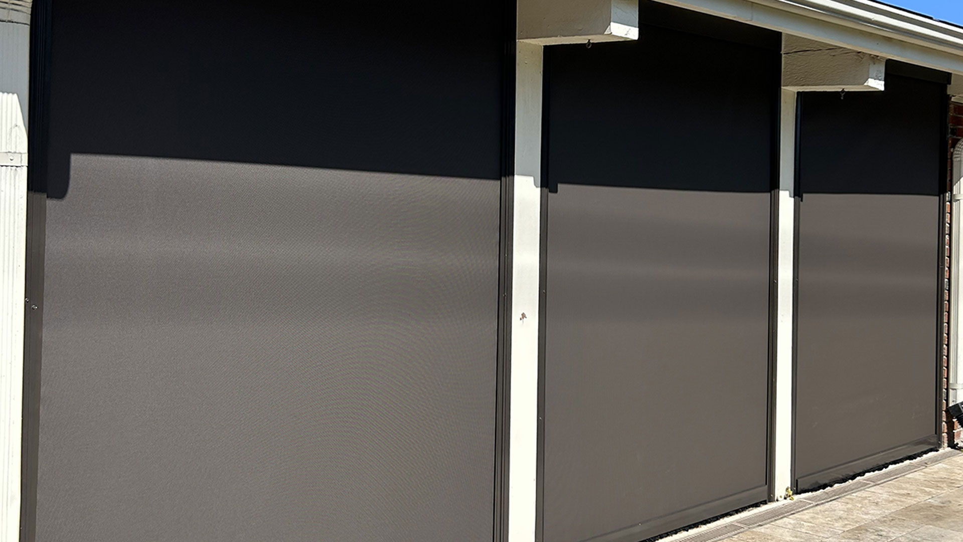 Close-up view of motorized motion screen fabric and track system installed in Lafayette, Louisiana