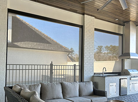 Motion screens installed on a patio seating area for shade and airflow in Lafayette, Louisiana